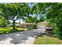 Inviting single-story home with a spacious driveway, lush trees and well maintained landscaping at 1508 Avenue H Ne, Winter Haven, FL 33881