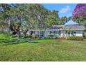 Well-maintained front yard featuring a mature tree and green lawn leading to a charming home at 1721 Cheyenne Trl, Maitland, FL 32751
