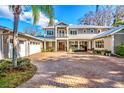 Beautiful two-story home with a brick driveway, manicured landscaping, and a three-car garage at 2118 Lake Dr, Winter Park, FL 32789