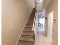 Carpeted staircase leading to the upper level, providing access to the home's living spaces at 2412 Caravelle Cir, Kissimmee, FL 34746