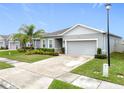 Beautiful curb appeal with a well-kept lawn, mature landscaping, and neutral color scheme at 3493 Lazy River Ter, Sanford, FL 32771