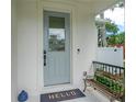 Charming home exterior with a light blue front door, welcome mat, and cozy bench at 350 E 2Nd Ave, New Smyrna Beach, FL 32169