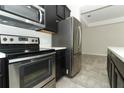 Close up of stainless steel refrigerator, stove, microwave, dark cabinetry and white countertops at 3557 Brighton Park Cir, Orlando, FL 32812