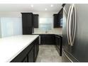 Bright kitchen with stainless steel appliances, dark cabinets, an island, and a view of the sink at 3557 Brighton Park Cir, Orlando, FL 32812