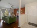 Cozy living room with hardwood floors, a green couch, and natural light from the sliding glass door at 4300 Hector Ct # 7, Orlando, FL 32822