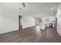 Bright living room showcasing an open floor plan with wood floors and access to the modern kitchen at 4470 Frances Ave, Sanford, FL 32773