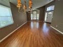 Spacious living room with hardwood floors, chandelier, ample natural light, and vaulted ceilings at 619 Blenheim Loop, Winter Springs, FL 32708