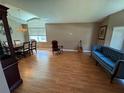 Spacious living room with a blue tufted sofa, rocking chair, and dining set with lots of natural light at 619 Blenheim Loop, Winter Springs, FL 32708