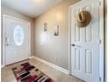Inviting foyer with decorative front door, neutral paint, tile floors, and a charming straw hat on the closet door at 7565 Dockside St, Winter Park, FL 32792