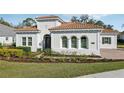 Beautiful single-story home with stucco facade, arched windows, and manicured landscaping at 8064 Peaceful Cir, Sanford, FL 32771