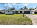 Charming single-story home featuring a well-manicured lawn and a two-car garage in a peaceful neighborhood at 1183 Feather Dr, Deltona, FL 32725