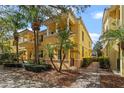 Beautiful yellow townhome with manicured landscaping, a brick walkway, and sunny skies at 11846 Nautica Dr, Orlando, FL 32827