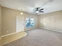 Bright living room with neutral carpet, ceiling fan, and lots of natural light at 1260 Honey Blossom Dr, Orlando, FL 32824