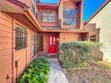 Charming home featuring a vibrant red front door, complemented by lush greenery and large windows at 136 Raintree Dr, Longwood, FL 32779