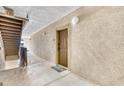 Hallway with a textured wall, showing the apartment door and stairway at 1371 Tuscan Terrace # 3203, Davenport, FL 33896