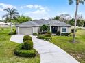 An elevated view of a well-maintained house with a winding driveway and green lawn at 1562 Auburn Oaks Ct, Auburndale, FL 33823