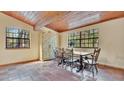 Elegant dining room featuring wood ceilings, rustic tile floors and large windows at 16318 Hamilton Dr, Orlando, FL 32833