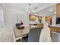 Cozy dining area with classic chandelier, adjacent to a kitchen space, and decorated with fresh flowers on the table at 2303 Mahoney Ave, Leesburg, FL 34748