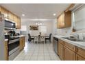 Bright kitchen with wood cabinets, white countertops, and stainless steel appliances adjacent to a formal dining area at 2303 Mahoney Ave, Leesburg, FL 34748