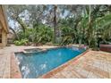 Inviting pool with hot tub and waterfall feature surrounded by lush tropical landscaping at 2958 Willow Bay Ter, Casselberry, FL 32707