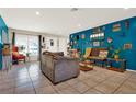 Open-concept living room with tile flooring, bright blue walls, and abundant natural light at 30 Cornwall Ct, Casselberry, FL 32707