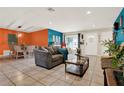 Open living room with tile flooring, a view of the dining area, and a cozy seating arrangement at 30 Cornwall Ct, Casselberry, FL 32707