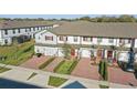 Well-maintained townhouses featuring brick driveways and attractive landscaping that enhances community appeal at 319 Smugglers Way, Apopka, FL 32712