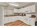 Bright kitchen featuring white cabinets, wood countertops, and hardwood flooring at 451 Hunter Cir, Kissimmee, FL 34758