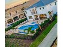 Aerial view of a backyard with a luxurious pool, spa, lounge chairs, and a fenced yard at 480 Muirfield Loop, Reunion, FL 34747