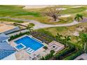 Aerial shot of a modern pool with lounge chairs, a spa, and a fire pit overlooking a golf course at 480 Muirfield Loop, Reunion, FL 34747