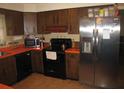 Traditional style kitchen featuring stainless steel refrigerator and black appliances at 5121 Hoperita St, Orlando, FL 32812