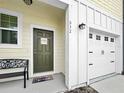 A charming yellow townhome showcasing a dark green front door and a single-car garage, bathed in sunlight at 532 Madison Dr, Davenport, FL 33837