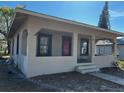 Single-story house featuring a covered porch, a red front door, and horizontal siding at 542 N 8Th St, Eagle Lake, FL 33839