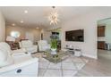 Bright living room featuring stylish furniture, a modern chandelier, and an open floor plan at 7517 Laureate Blvd # 4103, Orlando, FL 32827