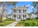 Charming two-story home featuring a spacious double porch, complemented by well-manicured landscaping and a welcoming walkway at 807 Oak Shadows Rd, Celebration, FL 34747