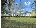 Expansive lawn showcasing a beautifully landscaped home with a two-story porch and lush green hedges at 807 Oak Shadows Rd, Celebration, FL 34747