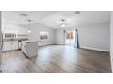 Bright open-concept living and kitchen area with modern light fixtures, wood flooring and stainless steel appliances at 1117 N Hart Blvd, Orlando, FL 32818