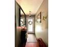 Interior hallway featuring a decorative mirror, wall decor, and coat rack with hardwood flooring at 11213 River Grove Dr, Orlando, FL 32817