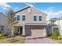 Charming two-story home boasts neutral stucco, stone accents, brick driveway and a welcoming covered front porch at 1129 Blue Garden Dr, Deland, FL 32720