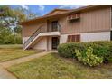 Inviting two-story exterior featuring well-maintained siding, trimmed bushes, and a staircase leading to the upper level entrance at 170 Palmetto Woods Ct # 3A, Deltona, FL 32725