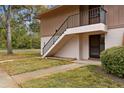 Inviting two-story exterior featuring well-maintained siding, trimmed bushes, and a staircase leading to the upper level entrance at 170 Palmetto Woods Ct # 3A, Deltona, FL 32725