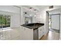 Modern kitchen features an open design, granite countertops, a stainless steel dishwasher, and a view of the open living area at 170 Palmetto Woods Ct # 3A, Deltona, FL 32725