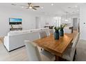 Open concept living space with a modern dining table and a comfortable sofa at 200 Snowy Orchid Way, Lake Alfred, FL 33850