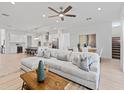 Spacious living room featuring a large sectional sofa, hardwood floors, and modern lighting at 200 Snowy Orchid Way, Lake Alfred, FL 33850