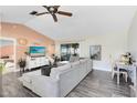 Bright living room featuring a large sectional sofa, ceiling fan, and sliding door access to the lanai at 2101 Lake Francis Dr, Apopka, FL 32712