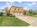Two story home with a terracotta tiled roof, an attached two car garage, and well-manicured landscaping at 2326 Wintermere Pointe Dr, Winter Garden, FL 34787