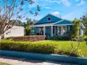 Beautiful blue home boasts manicured lawn with lush greenery and shrubs along the walkway at 434 E Harding St, Orlando, FL 32806