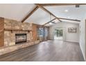 Spacious living room featuring a stone fireplace, high vaulted ceilings with wood beams, and hardwood floors at 655 E Lake View Rd, Lake Alfred, FL 33850
