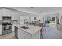 Open-concept kitchen with a large island, modern stainless steel appliances, and a seamless flow into the living area at 7412 Sw 76Th Ter, Ocala, FL 34481