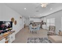 Bright and airy living room featuring an open layout, wood-look flooring, and a comfortable seating area at 7412 Sw 76Th Ter, Ocala, FL 34481